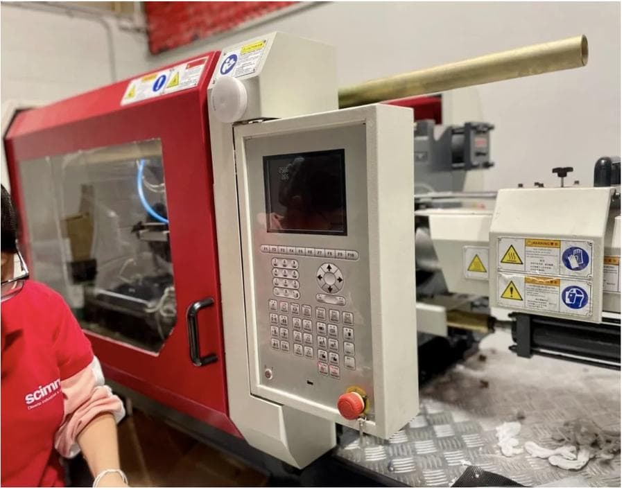 Operador de Scimmia en el panel de control de una máquina de inyección